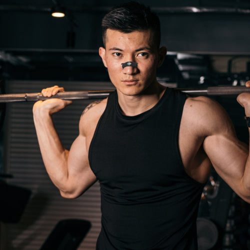 Man lifting a barbell in a gym setting