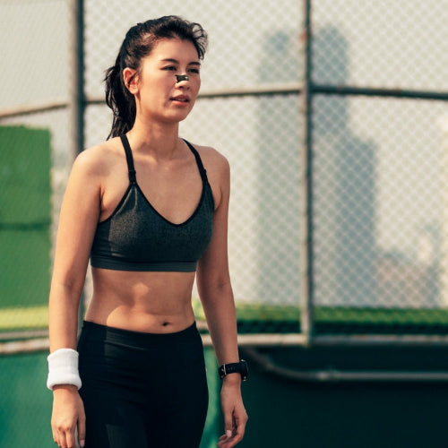 Woman in athletic wear standing on a tennis court