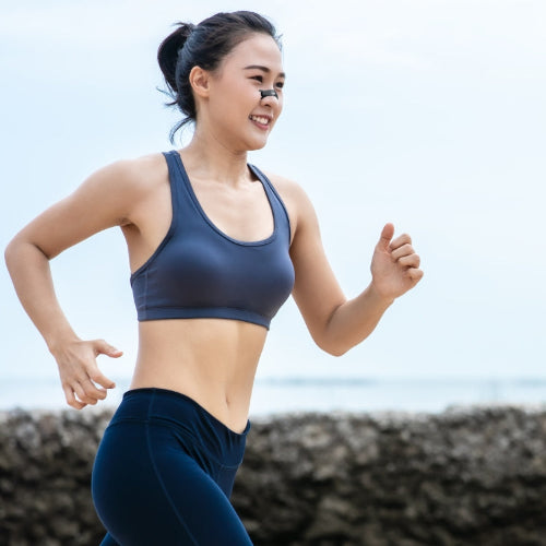 Woman in athletic wear standing outdoors with a blurred background